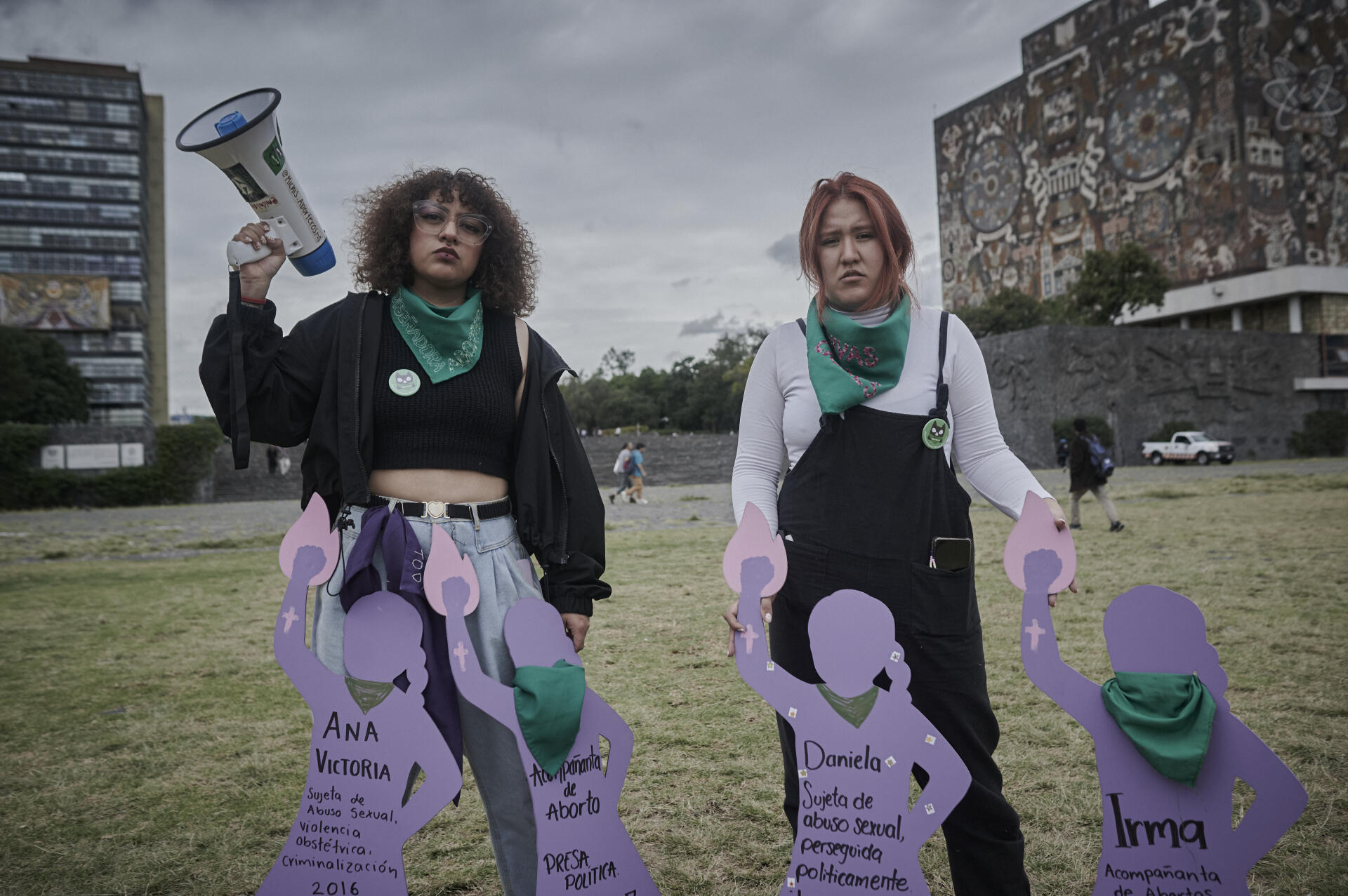 Dos activistas feministas posan con siluetas que simbolizan a mujeres víctimas de violencia, en la Ciudad de México, el 23 de noviembre de 2023.